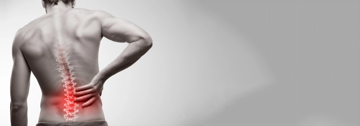 A man holding his lower back in pain.